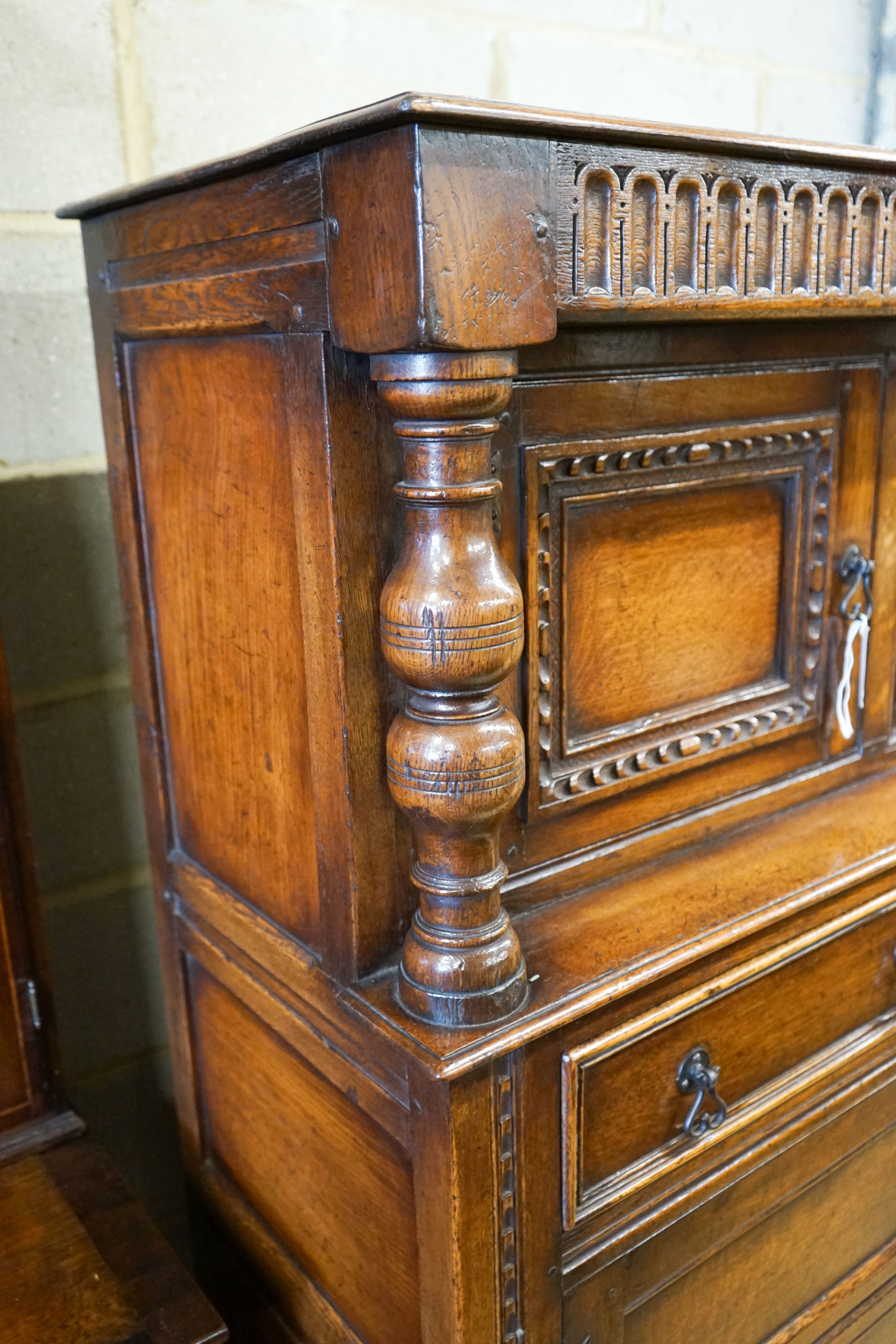 A 17th century style carved and panelled oak court cupboard